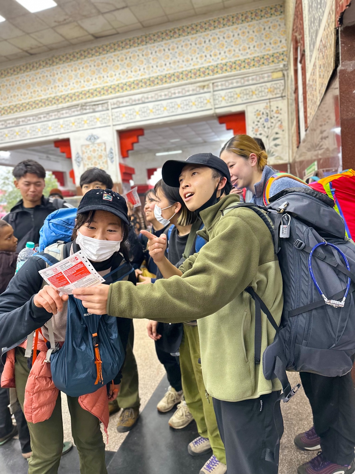 駅で切符を確認しながら行き方を考える参加者