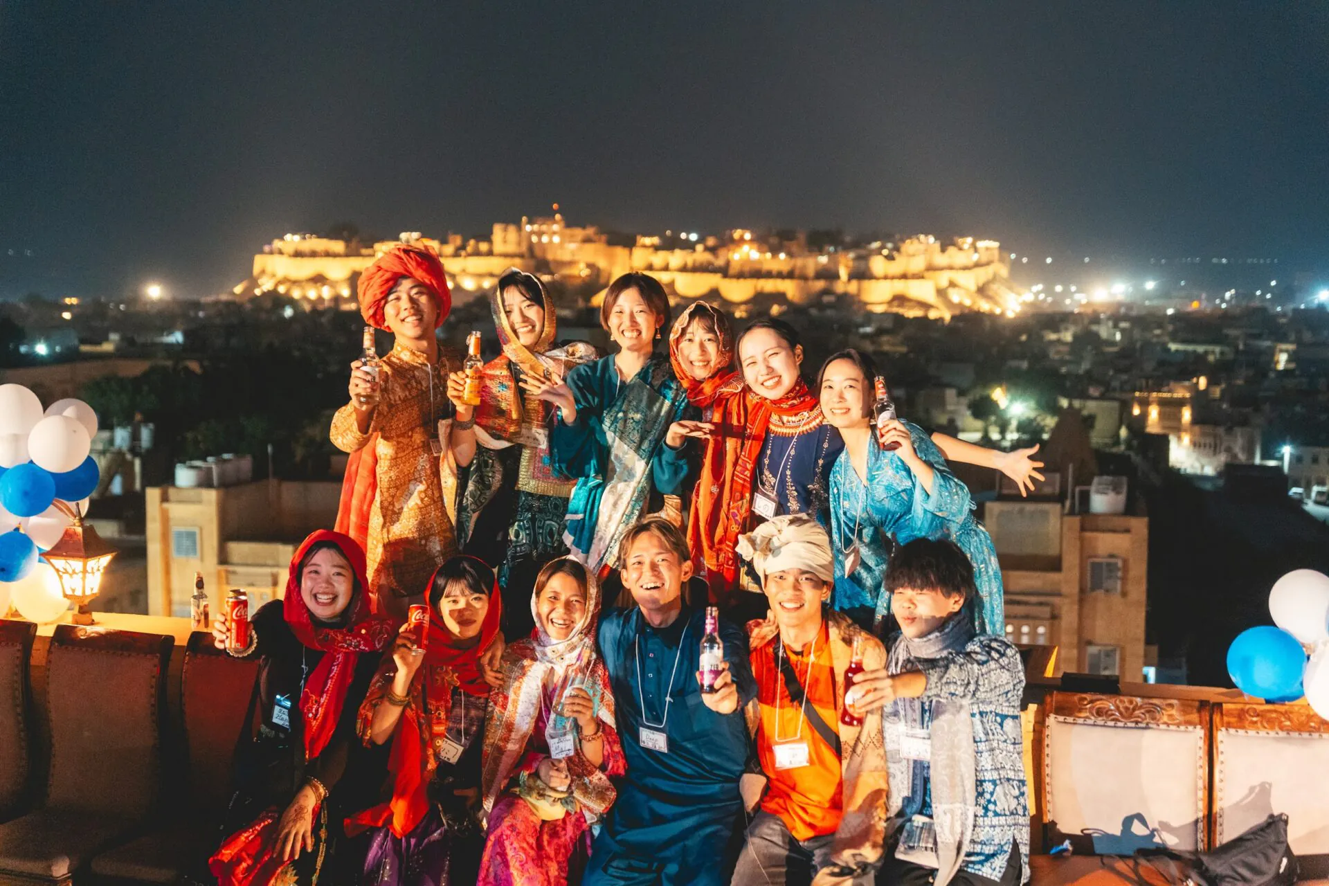 ジャイサルメールの城を背景にカラフルなサリー姿で集まる前夜祭の参加者