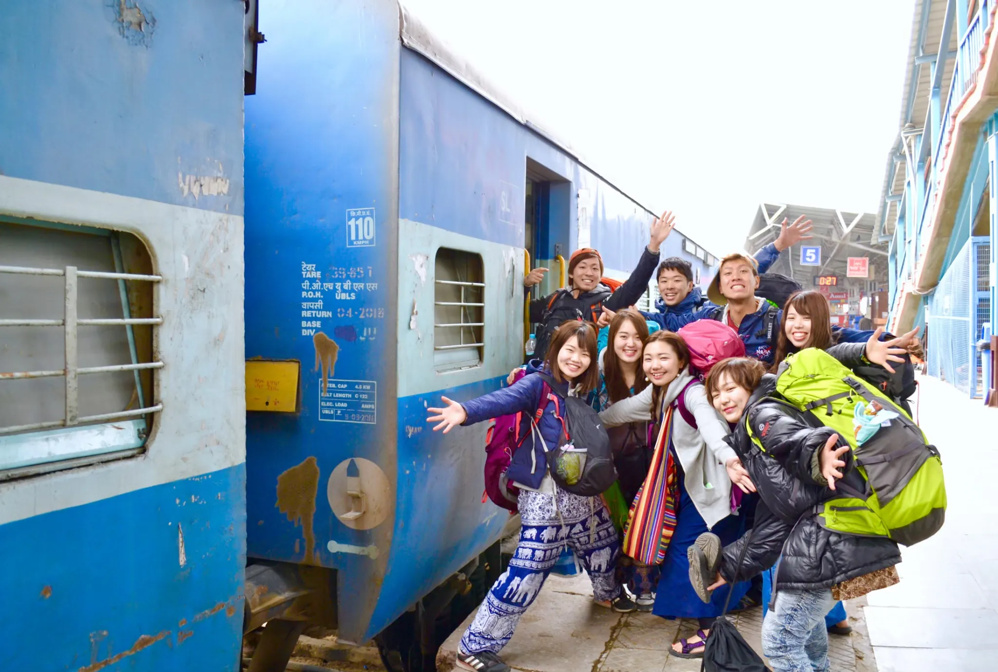 インドの駅で列車と一緒に笑う旅の仲間