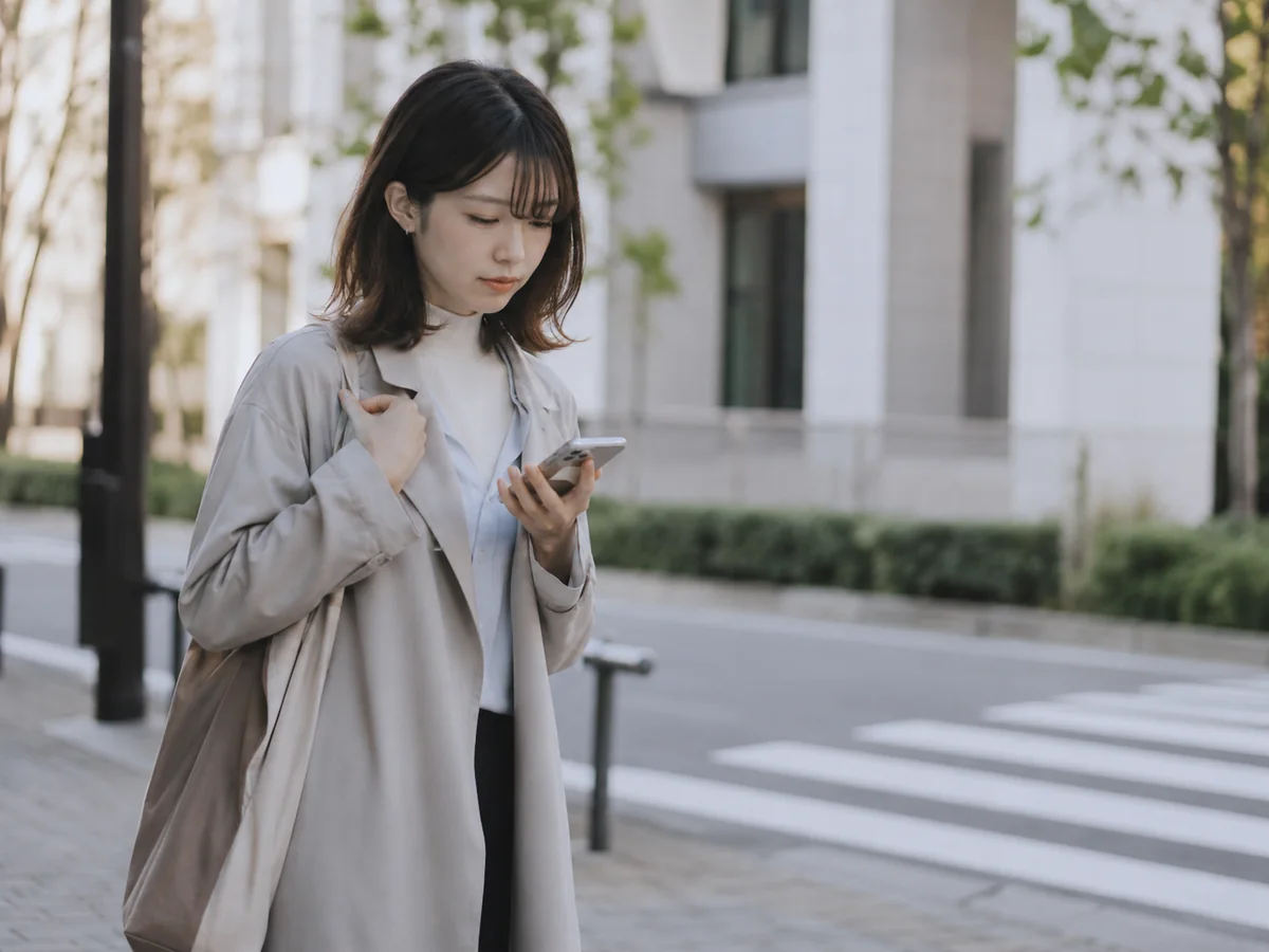 一歩踏み出せずスマートフォンを見つめる人