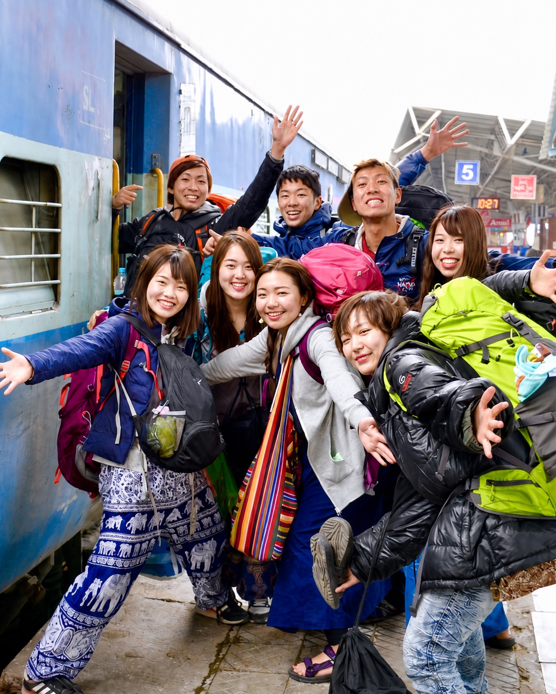 インドの駅で列車を前に笑顔を見せるCHANGE JOURNEYの仲間たち
