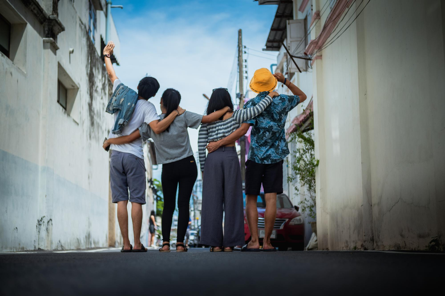 旅先の街を肩を組んで歩く仲間たち