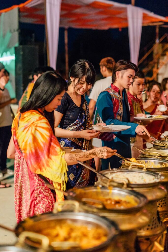 インドの砂漠で年越しパーティー中にインドカレーを食べる参加者の様子イメージ