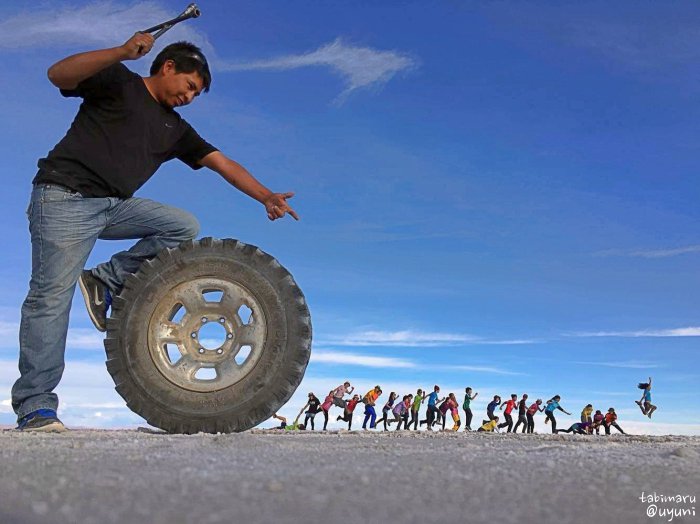 ウユニ塩湖でトリックアート写真を撮影するタビイク参加者