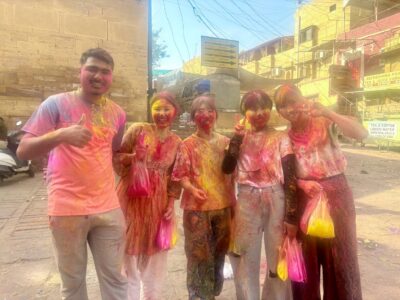 色粉で全身カラフルになったホーリー祭の参加者の女の子たちとインドのおじさん